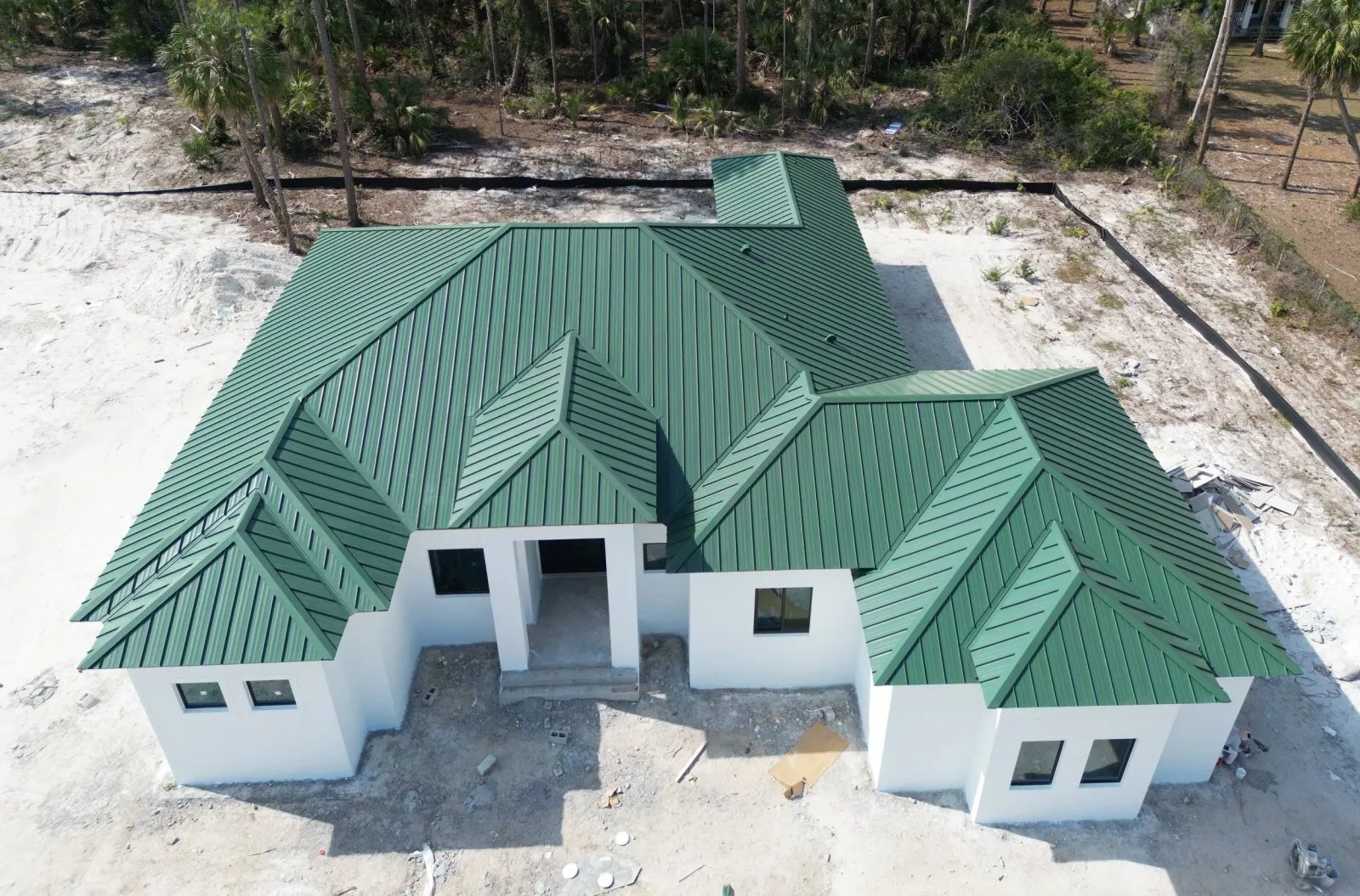 Green metal roof on a new home, aerial view
