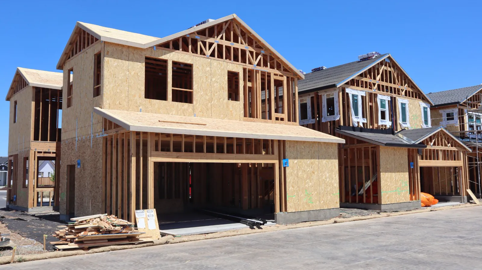 New homes under construction with roof framing and sheathing installed
